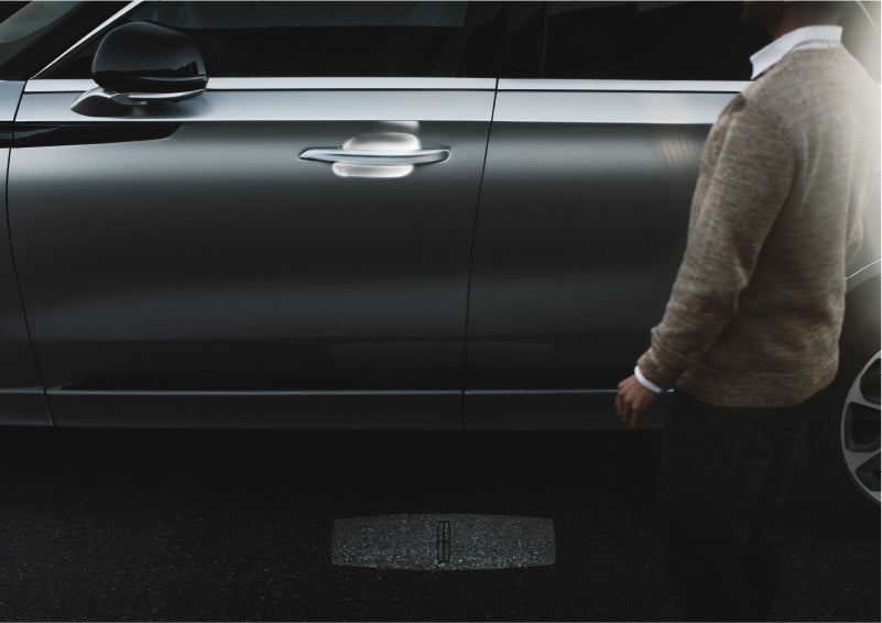 A person approaches a 2023 Lincoln Aviator® Grand Touring as the Lincoln Embrace sequence of welcome lighting illuminates | Vance Lincoln in Miami OK