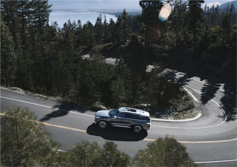 A 2023 Lincoln Aviator® SUV is being driven on a winding mountain road | Vance Lincoln in Miami OK