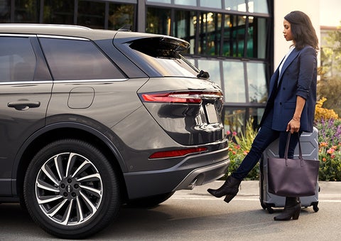 A woman with her hands full uses her foot to activate the available hands-free liftgate. | Vance Lincoln in Miami OK