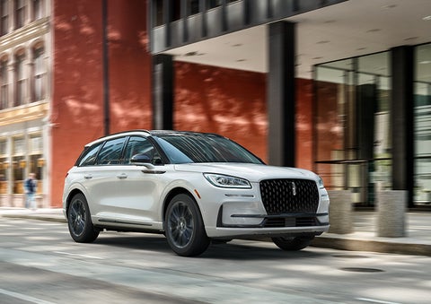 The 2024 Lincoln Corsair® SUV with the Jet Appearance Package and a Pristine White exterior is parked on a city street. | Vance Lincoln in Miami OK
