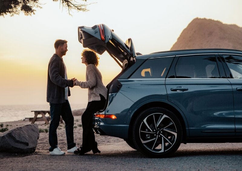A couple share a moment together outside a 2025 Lincoln Corsair® SUV near the open liftgate. | Vance Lincoln in Miami OK