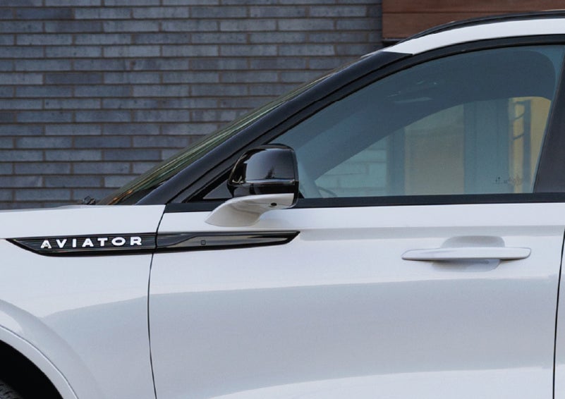 The driver’s side door and fender badging of a white 2026 Lincoln Aviator® SUV are showcased. | Vance Lincoln in Miami OK