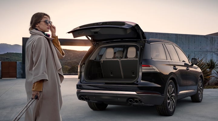 A woman approaches a 2026 Lincoln Aviator® SUV with its rear liftgate open. | Vance Lincoln in Miami OK