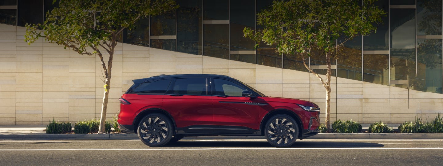 A 2026 Lincoln Nautilus® SUV with an available Hybrid Powertrain is parked in an urban setting. | Vance Lincoln in Miami OK