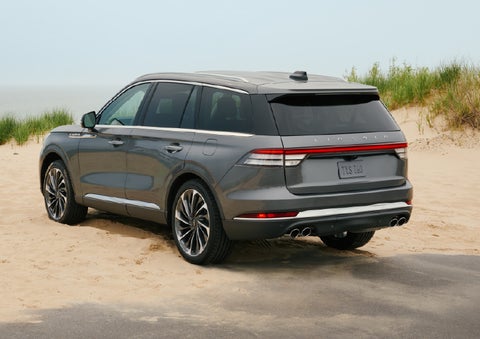 A 2027 Lincoln Aviator® SUV is parked next to sand dunes. | Vance Lincoln in Miami OK