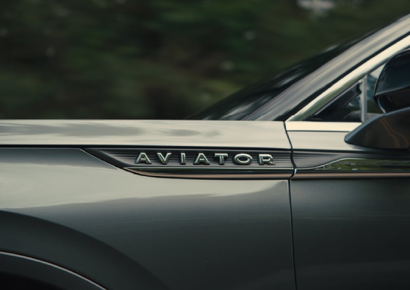 The driver’s side door and fender badging of a gray 2027 Lincoln Aviator® SUV are showcased. | Vance Lincoln in Miami OK