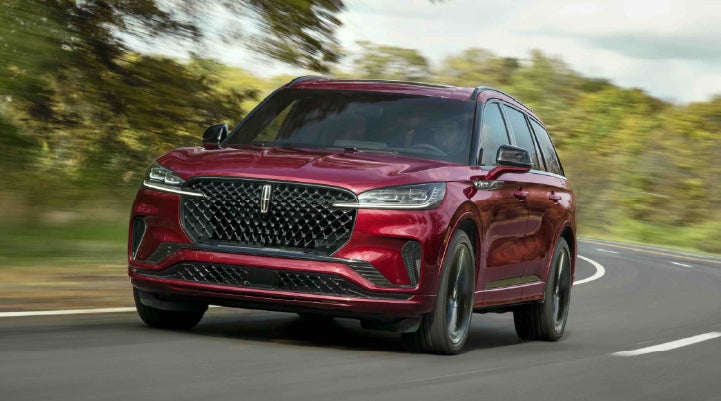 A 2027 Lincoln Aviator® SUV is being driven on a country road | Vance Lincoln in Miami OK